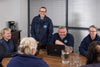 A group of people laughing in a boardroom
